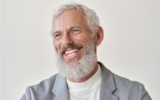 Smiling bearded man in agray jacket