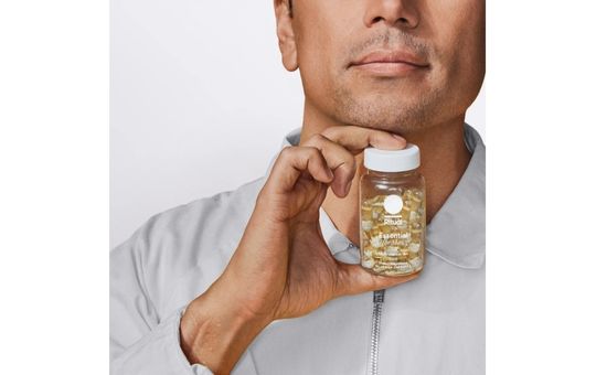 man holding a bottle of ritual essentials vitamins for men
