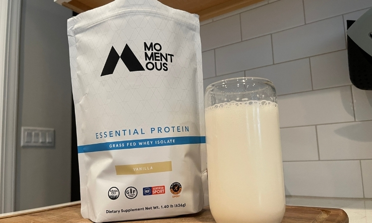 momentous whey protein powder in glass cup